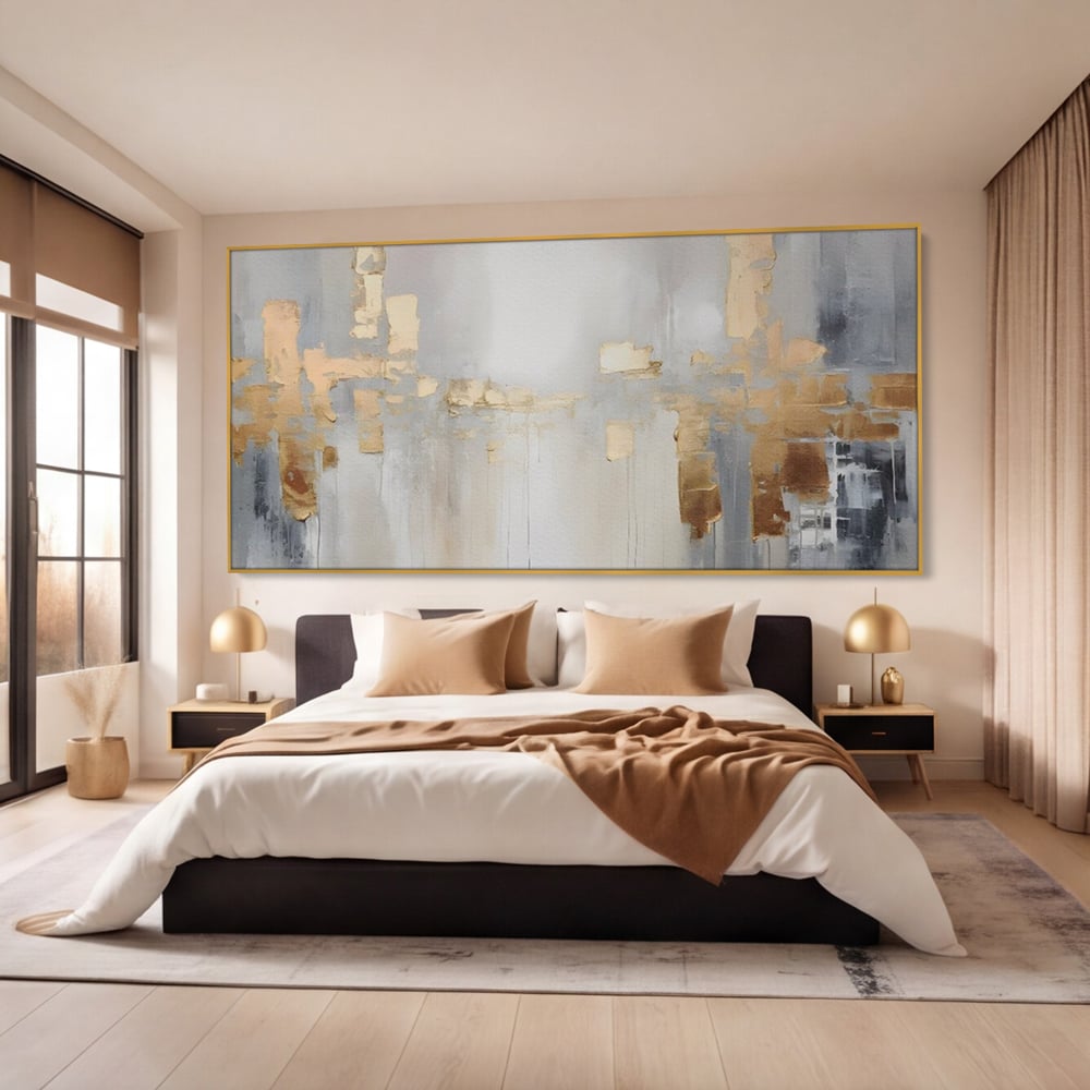 Tablou canvas cu pictura abstracta cu pete aurii si gri, in rama de aluminiu auriu, pe perete intr-un dormitor